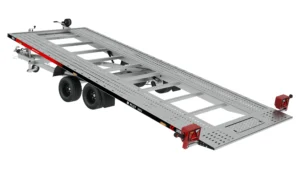 La remorque PLI27-5021 est une remorque plate automobile, équipée d'un châssis métallique, d'un double essieu et de rampes de chargement perforées. Sa plateforme vide est légèrement inclinée, facilitant ainsi le chargement et le transport de véhicules.