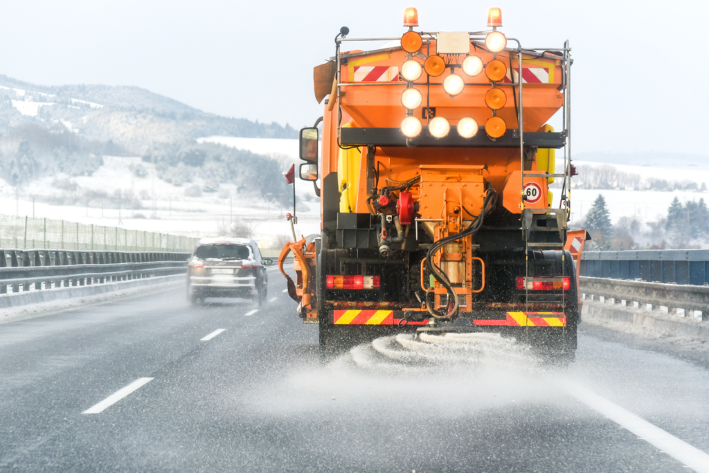 Samochód rozsypujący sól na autostradzie