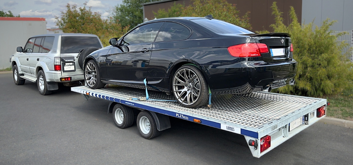 teures schwarzes Auto auf einem Abschleppwagen