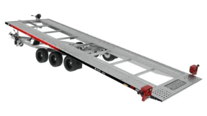 La Laweta PLI35-6021 es un remolque plataforma diseñado para el transporte de automóviles, equipado con una rampa metálica abatible, tres ejes con seis ruedas y reflectores de seguridad rojos en la parte trasera, diseñado para un transporte de vehículos seguro y eficiente.